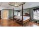 A spacious main bedroom features a wooden four poster bed, tray ceiling, and lots of natural light at 1564 Beaver Creek Lane, Snellville, GA 30078