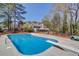 Fenced pool area with diving board and slide, complemented by the house's rear elevation and ample yard space at 1564 Beaver Creek Lane, Snellville, GA 30078