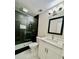 Modern bathroom design with black shower enclosure, white vanity, and mosaic floor at 6123 Deerfield Ct, Morrow, GA 30260