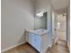 This bathroom features a dual vanity with mirror and lighting, wood floors, and leads into the bedroom at 6808 Foxfire Pl, South Fulton, GA 30349
