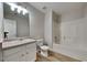 Bright bathroom featuring a tub shower, white toilet, wood-look flooring, and single sink vanity at 6808 Foxfire Pl, South Fulton, GA 30349