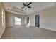 This is a cozy bedroom with carpet flooring, tray ceiling with fan, and a bright window at 6808 Foxfire Pl, South Fulton, GA 30349