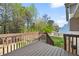 Inviting back deck with brown wooden railings overlooking the yard and a beautiful green landscape at 2876 Davis Mill N Rd, Dallas, GA 30157