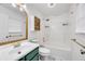 Bright bathroom with a green vanity, decorative mirror, and a shower-tub combo with stylish fixtures at 2876 Davis Mill N Rd, Dallas, GA 30157