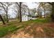 A spacious backyard with a white house, green grass, and mature trees, offering a serene outdoor space at 3888 W Oak Dr, Douglasville, GA 30135