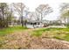 A nice backyard featuring green grass and a charming white house surrounded by trees at 3888 W Oak Dr, Douglasville, GA 30135