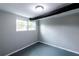 Cozy basement bedroom with neutral walls, a window with natural light, and grey painted floors at 3888 W Oak Dr, Douglasville, GA 30135
