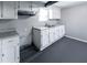 The basement kitchen offers white cabinets, grey countertops, and a stainless steel double sink under the window at 3888 W Oak Dr, Douglasville, GA 30135