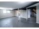 Spacious basement featuring grey painted floors, support beams, and a glimpse into other rooms at 3888 W Oak Dr, Douglasville, GA 30135