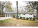 Charming single-story home with a brick facade, bright green front door, and attached carport in a wooded setting at 3888 W Oak Dr, Douglasville, GA 30135