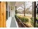 View of the quaint front porch with iron railings, charming shuttered windows, and a view of the street at 3888 W Oak Dr, Douglasville, GA 30135