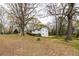 Spacious side yard of this home in a wooded setting with mature trees, offering ample outdoor space at 3888 W Oak Dr, Douglasville, GA 30135