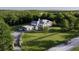 Stunning aerial view of a white farmhouse-style home with long driveway and lush green surroundings at 4385 Hickory Flat Hwy, Canton, GA 30115