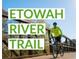 A sunny view of the Etowah River Trail with a cyclist enjoying the scenic route across a bridge at 4385 Hickory Flat Hwy, Canton, GA 30115