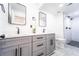 Modern bathroom featuring a double vanity, marble countertops, and a glass enclosed shower with dual shower heads at 716 Sunfield Nw Dr, Lilburn, GA 30047