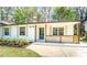 Charming one-story home with a well-manicured lawn, fresh flowers, and a blue front door at 716 Sunfield Nw Dr, Lilburn, GA 30047