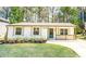 Charming one-story home with a well-manicured lawn, fresh flowers, and natural wood porch accents at 716 Sunfield Nw Dr, Lilburn, GA 30047