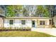 Charming one-story home with a well-manicured lawn, fresh flowers, and natural wood porch accents at 716 Sunfield Nw Dr, Lilburn, GA 30047