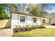 Charming one-story home with a well-manicured lawn, fresh flowers, and natural wood porch accents at 716 Sunfield Nw Dr, Lilburn, GA 30047
