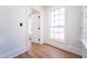 Bright hallway with hardwood floors, white trim and walls, and a window letting in natural light at 716 Sunfield Nw Dr, Lilburn, GA 30047