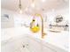 Close-up of a white farmhouse sink and gold faucet on a large kitchen island at 716 Sunfield Nw Dr, Lilburn, GA 30047
