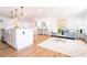 Open-concept living space with sleek wood flooring, modern decor, and a charming kitchen island at 716 Sunfield Nw Dr, Lilburn, GA 30047