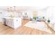 Open concept living room featuring an eat-in kitchen with a white island, stainless steel appliances, and wood flooring at 716 Sunfield Nw Dr, Lilburn, GA 30047