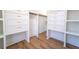 Spacious walk-in closet with custom shelving and drawers, and hardwood floors at 716 Sunfield Nw Dr, Lilburn, GA 30047