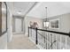 Upstairs hallway featuring a statement light fixture, neutral carpet, and stairway access at 140 Kirkland Dr, Lawrenceville, GA 30044