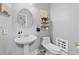 Cozy powder room featuring a pedestal sink, wall-mounted storage, and stylish decor at 140 Kirkland Dr, Lawrenceville, GA 30044