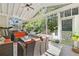 Light-filled sunroom with tile floors, wicker furniture, string lights, and views of backyard at 140 Kirkland Dr, Lawrenceville, GA 30044