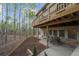 Backyard view featuring a covered outdoor patio with dining table and second story deck with a forest view at 420 Longs Peak, Johns Creek, GA 30022