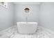Bathroom featuring a contemporary freestanding tub, octagonal window and stylish marble flooring for a relaxing experience at 420 Longs Peak, Johns Creek, GA 30022