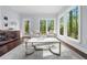 Inviting living room with large windows, plush seating, stylish rug, and scenic backyard views at 420 Longs Peak, Johns Creek, GA 30022