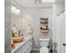 Bright bathroom featuring marble tiling, storage shelves, and unique stone sink basin at 1445 Bentcreek Dr, Marietta, GA 30062