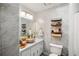 Bathroom with modern vanity, bowl sink, marble-look walls, and sleek shelving for storage and decor at 1445 Bentcreek Dr, Marietta, GA 30062