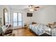 Cozy bedroom featuring light wood floors, a ceiling fan, and a large window at 1445 Bentcreek Dr, Marietta, GA 30062
