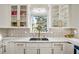 Bright kitchen features white cabinetry with gold hardware, white subway tile backsplash and stainless steel sink at 1445 Bentcreek Dr, Marietta, GA 30062