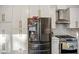 Close-up shot of the kitchen appliances and white cabinets with modern gold hardware and subway tile backsplash at 1445 Bentcreek Dr, Marietta, GA 30062