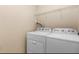 Laundry room with white washing machine and dryer, and storage shelves above at 201 Creel Way, Atlanta, GA 30349