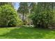 Beautiful backyard with lush lawn, framed by mature trees and foliage, offering a tranquil outdoor escape at 2628 Rivers Nw Rd, Atlanta, GA 30305