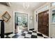 Foyer with checkered flooring, chandelier, and view into the dining room at 2628 Rivers Nw Rd, Atlanta, GA 30305