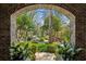 Picturesque front entrance framed by a brick archway and lush landscaping at 2628 Rivers Nw Rd, Atlanta, GA 30305