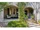 Charming covered front porch with brick columns, comfortable seating, and lush greenery at 2628 Rivers Nw Rd, Atlanta, GA 30305