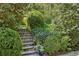 Beautiful garden with stone steps surrounded by lush greenery and blooming flowers at 2628 Rivers Nw Rd, Atlanta, GA 30305