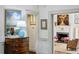 Hallway showcasing wood chest, artwork, and a glimpse into the living room with fireplace at 2628 Rivers Nw Rd, Atlanta, GA 30305