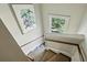 Well-lit staircase featuring neutral carpet, painted walls, wood handrail, and window views at 2628 Rivers Nw Rd, Atlanta, GA 30305