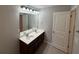 Bathroom featuring tile floors, double sinks with a dark vanity, and a large framed mirror at 2460 Laurel Gate Ln, Cumming, GA 30040