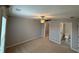 A primary bedroom featuring plush carpet, ceiling fan, and a view into the ensuite bathroom and walk-in closet at 2460 Laurel Gate Ln, Cumming, GA 30040