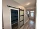 Hallway with closet featuring a sliding wood door, and bright natural light at 2460 Laurel Gate Ln, Cumming, GA 30040